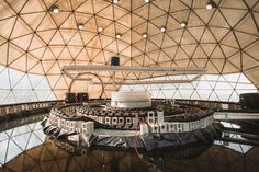 the inside of a large dome structure with many windows and lights hanging from it's ceiling