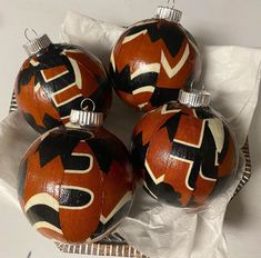 four orange and black ornaments sitting on top of each other