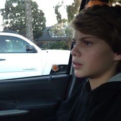 a young boy sitting in the passenger seat of a car