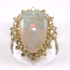 This Is A Fine Huge Pear Cut Fire Opal Cocktail Ring W/Diamond Spiderweb Halo. It Is Made Of 100% Natural 14kt Yellow Gold And Is In Brand New Condition. It Has A Ctw Of 5.42ct (.74 Diamond/4.68 Opal) And Weighs 5.4 Grams. The Fancy Diamonds Have A Clarity Of Si2 And G Color. This Beautiful Custom Piece Has An Excellent Pear Cut Opal Stone, Surrounded By A Diamond Spiderweb Halo. This Ring Is The Latest In Fashion Design Having Unique Designer Qualities That Is Full Of Shine And Clarity. Yellow Gold Opal Ring With Brilliant Cut Diamond, Opal Ring With Prong Setting In Yellow Gold, Yellow Gold Opal Ring With Diamond Prong Setting, Luxury Yellow Gold Opal Ring With Halo Design, Luxury Halo Opal Ring, Formal Yellow Gold Pear-shaped Opal Ring, Formal Pear-shaped Yellow Gold Opal Ring, Gold Pear-shaped Opal Ring For Formal Occasions, Pear-shaped Yellow Gold Opal Ring