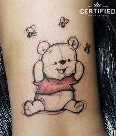 a small tattoo of a teddy bear with bees on it's leg and chest