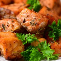 some food is on a white plate with parsley around it and garnish