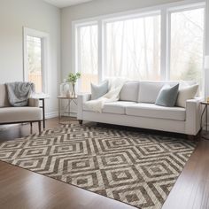 a living room with white couches and large windows in the back ground is a wood floor