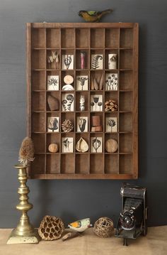 an old wooden box with various items in it on a table next to a lamp