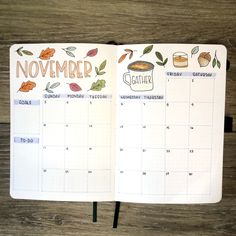 an open planner with the words november written on it and some leaves around it, sitting on a wooden surface