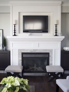 the fireplace is decorated in white and has a flat screen tv above it