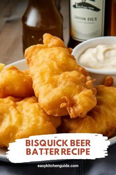 a white plate topped with tater tots next to a bottle of beer and lemon wedges