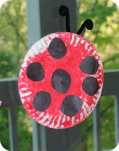 a paper plate with a ladybug on it sitting in front of a window