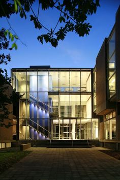 a large building with many windows and steps leading up to the front door at night