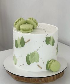 a white cake with green macaroons on top