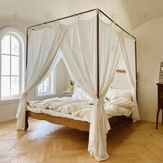 a canopy bed with white drapes on it in a bedroom next to a window