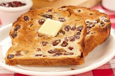 two pieces of bread on a plate with butter and raisins