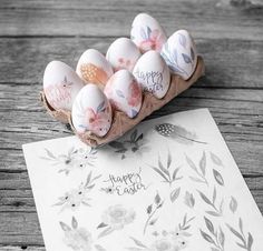 some eggs are sitting in a carton on a table with a happy easter card