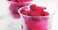 two glasses filled with ice cream and raspberry sorbs on a table