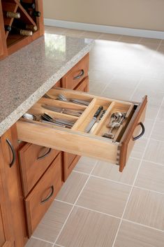 an open drawer in the middle of a kitchen