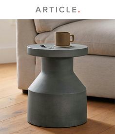 a table with a coffee cup on it in front of a couch and the words article