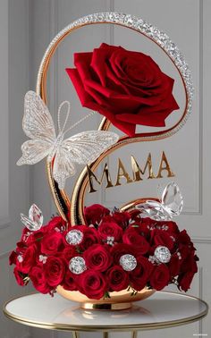 a bouquet of red roses in a gold vase with the word mama written on it