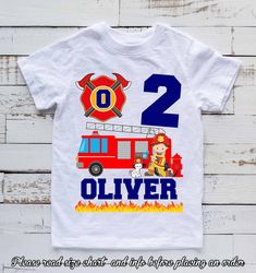 a t - shirt with the number two on it and firetruck in front