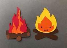 two pieces of paper cut out to look like campfire and firewood with faces on them