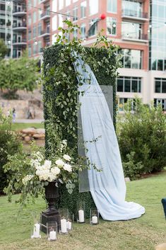 an outdoor ceremony setup with flowers and greenery on the ground, surrounded by candles