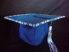 a blue graduation cap with tassels and beads on the top is sitting in front of a black background