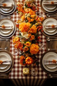 the table is set for thanksgiving dinner with pumpkins, flowers and gourds