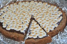 a chocolate pie with marshmallows on top is shown in tin foil, ready to be eaten