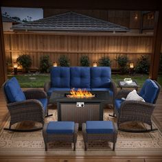 a fire pit sitting on top of a wooden deck next to chairs and tables with blue cushions