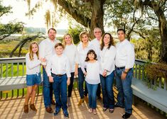 a family posing for a photo on a porch in front of a large oak tree