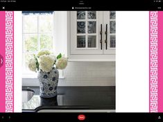 a vase filled with white flowers sitting on top of a counter