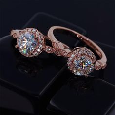 two rose gold wedding rings with diamonds on black background, close up view from above