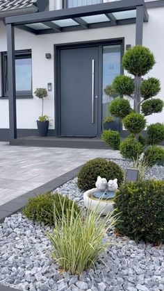 a house with some plants in front of it and a stone path leading to the door