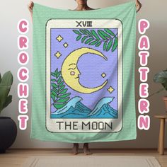 a woman holding up a blanket with the moon on it