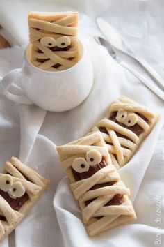 some kind of food with googly eyes on it sitting in front of a cup