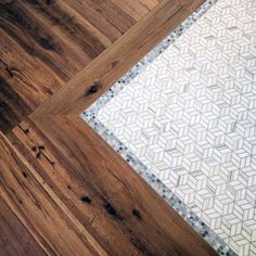 the floor is made from wood and has white tiles on it, along with an area rug