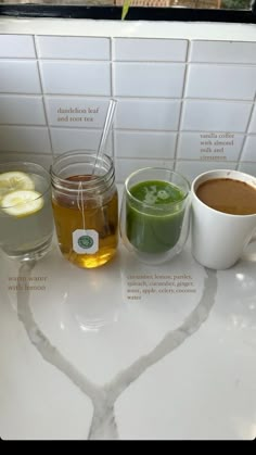 three different types of drinks on a counter with the names of each beverage in front of them