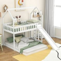 a white bunk bed with a slide in front of it