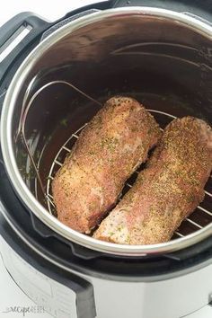 two pieces of meat are sitting in an air fryer