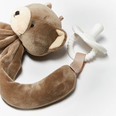 a brown stuffed animal with a pacifier attached to it's back and neck