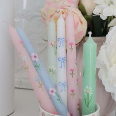 some candles are sitting in a vase with flowers