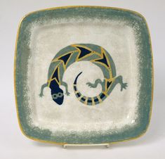 a green and yellow plate with a lizard on it