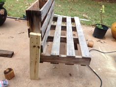 a wooden bench sitting on top of a cement ground