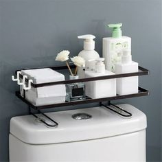 a bathroom shelf with soap, lotion and other items on top of the toilet