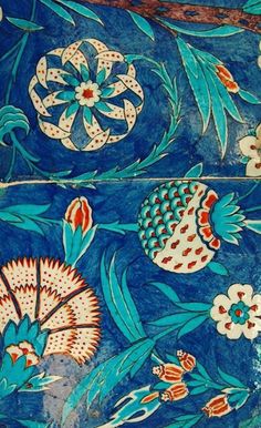 an intricately painted wall with flowers and leaves on it's side, in blue tones