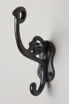 an iron hook on the side of a white wall