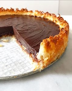 a chocolate pie with one slice missing from it on a pan covered in wax paper