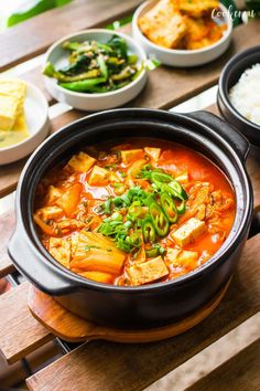 several bowls of food on a wooden table