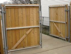 two wooden gates are open on the sidewalk