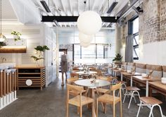 the interior of a restaurant with wooden tables and chairs, white walls and exposed ceilings