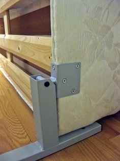 a close up of a wooden bed frame with metal brackets on the bottom and sides